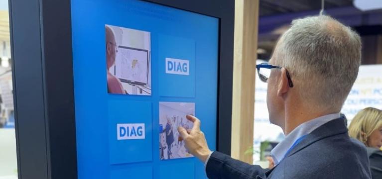 Homme jouant sur la borne intéractive DIAG